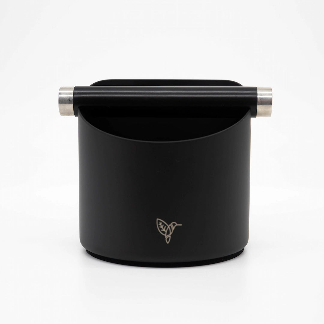 Black cylindrical coffee knock box container with rubber handle and silver accents on a white background. Barista Supplies Matte Black Metal Barista Knock Box - Coffee Gear Online Basic Barista