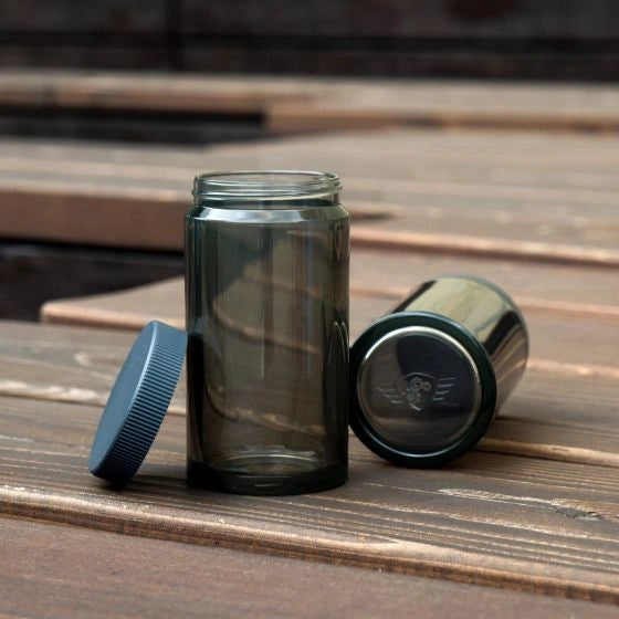 Two Comondante Polymer Bean jars with lids on a wooden surface