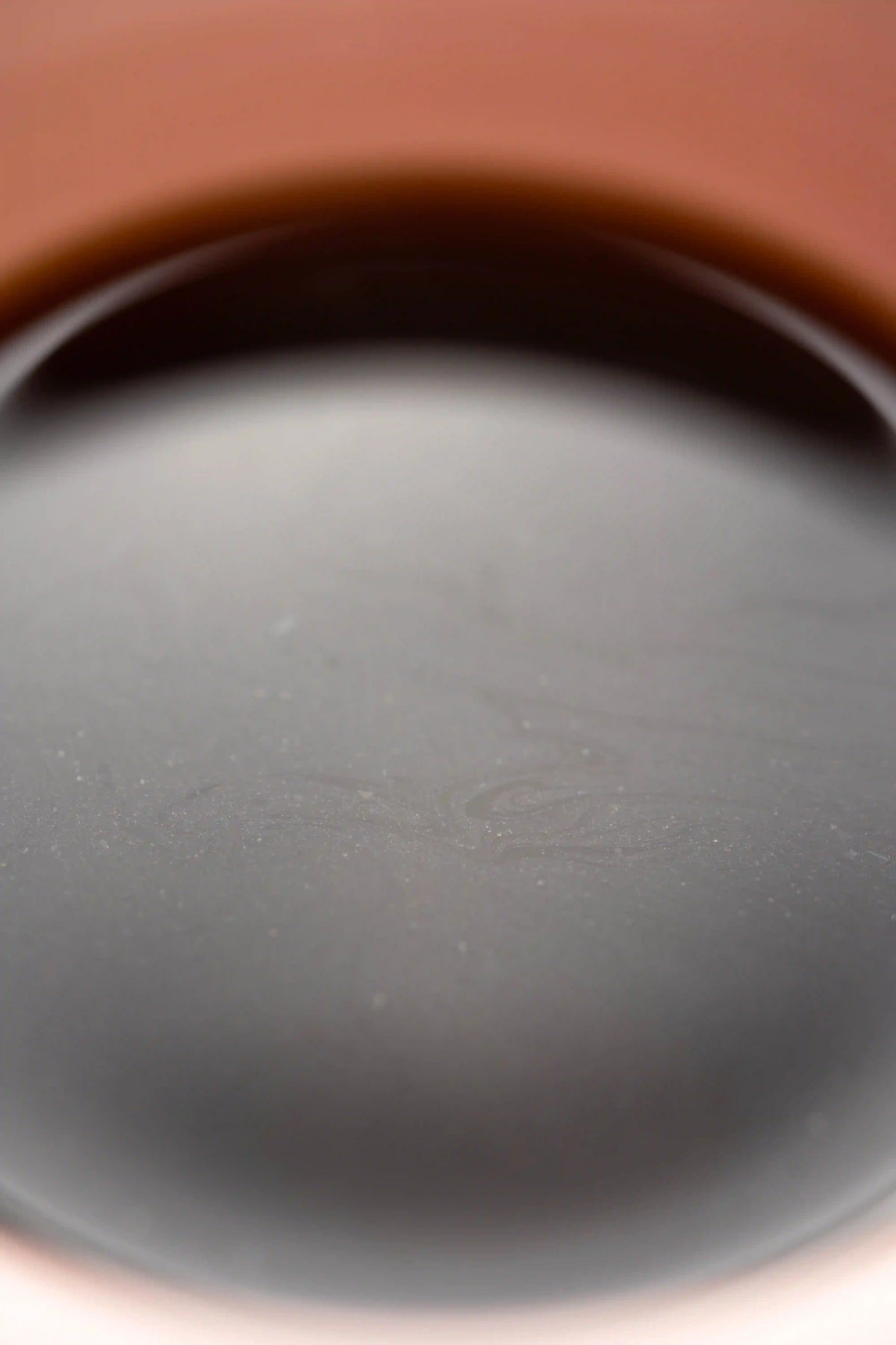 close up of Origami Sensory Cup Pink specialty coffee cup with coffee oils floating on the surface of the coffee. Basic Barista coffee science