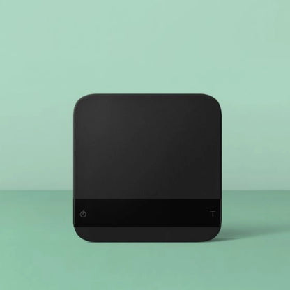 Black square Acaia Lunar Espresso scales with 'power' symbol button and 'tare' button on a light green background