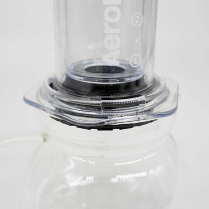 A 600ml glass coffee server carafe by Brewista, featuring a clear glass body, a black lid, and a clear glass handle, shown on a white background. AeroPress Compatible