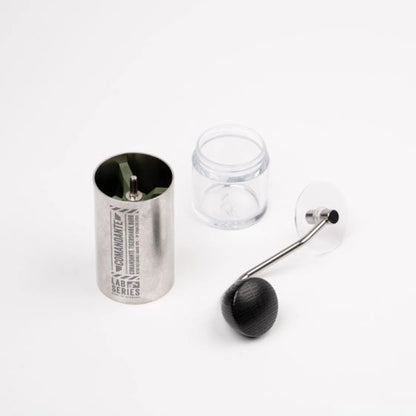 Metal canister, glass jar, and wooden crank on a white background Comandante coffee grinder with 'Comandante' branding, Stainless Steel Comandante C40 Tigershark Burrs Lab Series Coffee Grinder on a white background