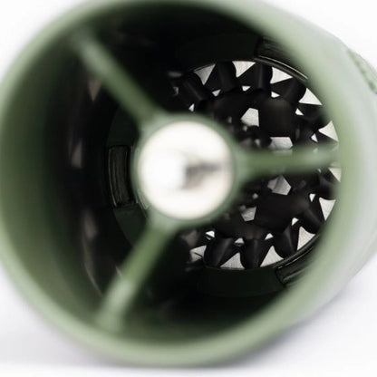 Close-up of a green travel coffee grinder with a black interior on a white background