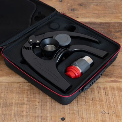 Black and red flair Neo Flex espresso maker in a protective travel case on a wooden surface Basic Barista Coffee Gear Online