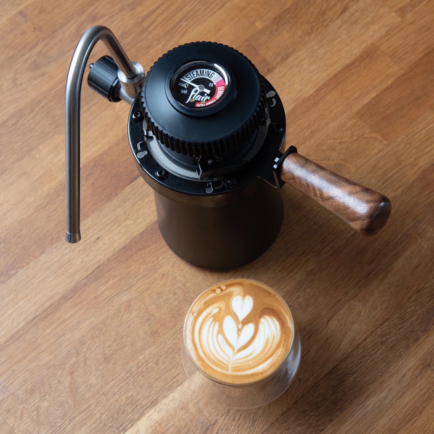 Flair Wizard Steamer stovetop Milk foamer Basic Barista Coffee Gear  on wooden background with a latte and latte art