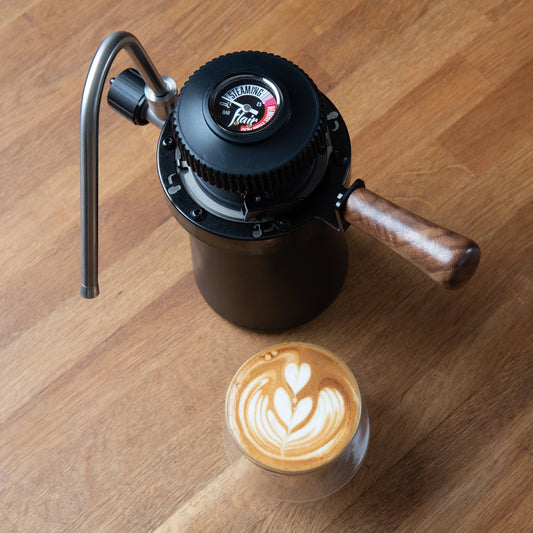 Flair Wizard Steamer stovetop Milk foamer Basic Barista Coffee Gear  on wooden background with a latte and latte art