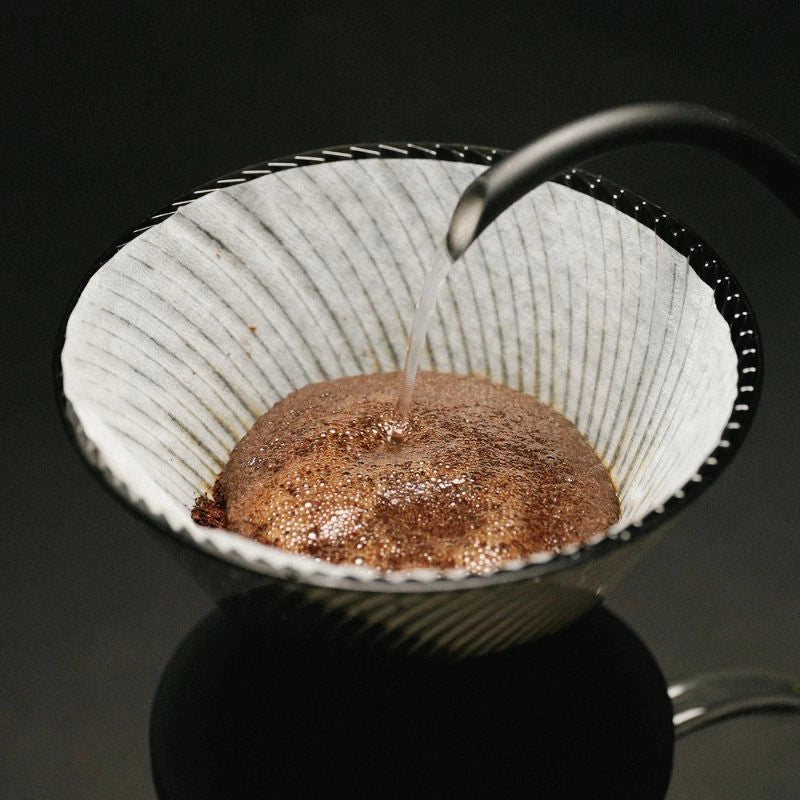 Hario V60 NEO Dripper Black Coffee Pour Over Cone Dirpper ribbed walls brewing filter coffee on black background with gooseneck kettle spout

