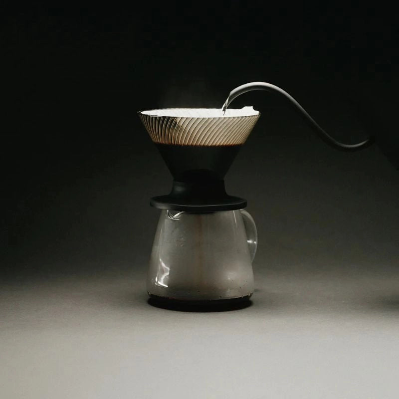 Hario V60 NEO Dripper Black Coffee Pour Over Cone Dirpper ribbed walls brewing filter coffee on black background with gooseneck kettle spout Basic Barista cinematic pour over coffee image
