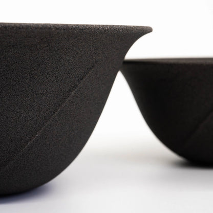 Two black ceramic filter / dripper small size and large size - on a white background / cinematic close up