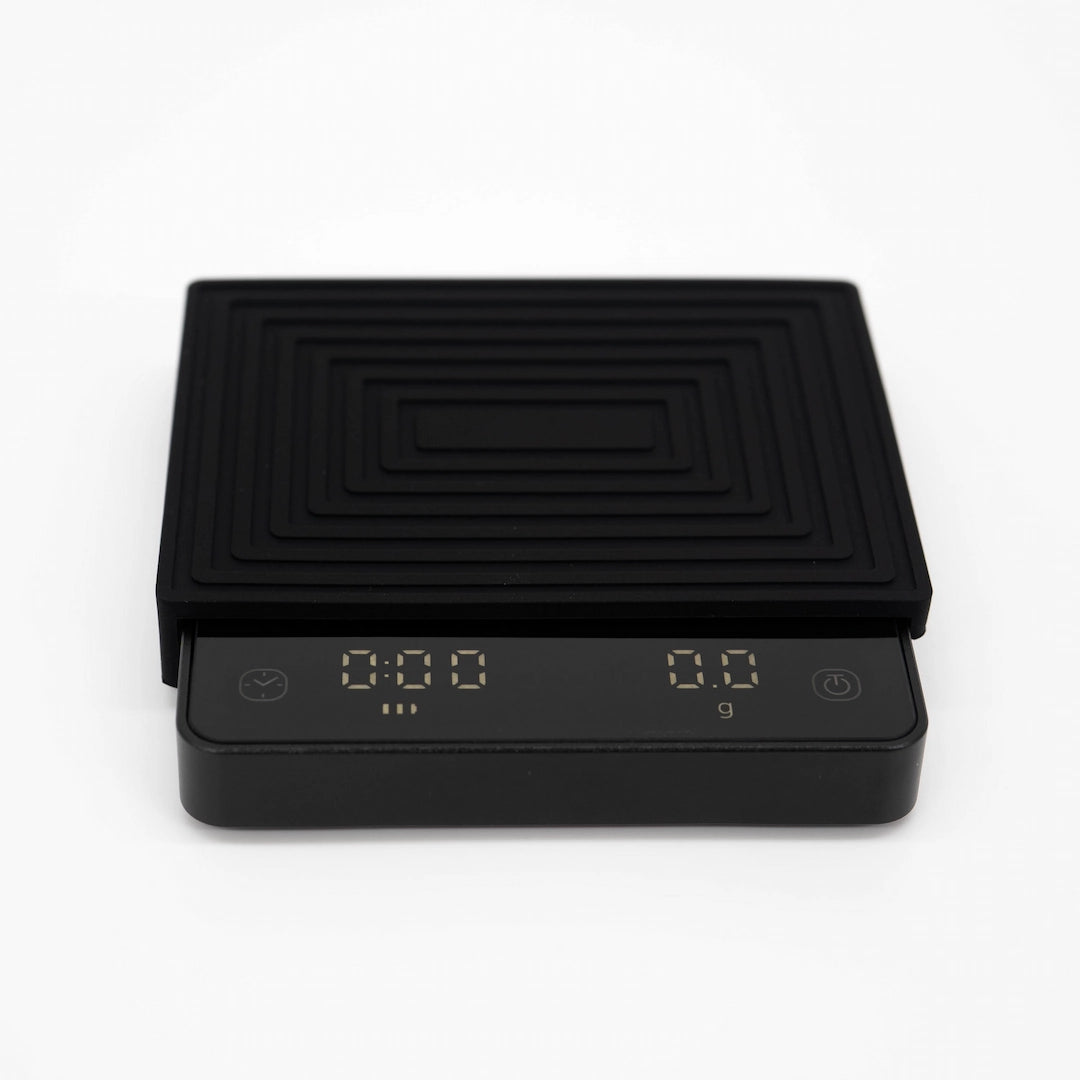 Digital scale with a black and gold heat pad on a white background Matrix G1 FlowBar Smart Pocket Coffee Scale Basic Barista Coffee Gear