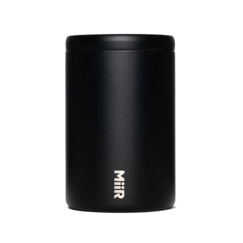 A matte black cylindrical insulated container with a matching lid, featuring the vertical white 'Miir' logo near the bottom, set against a plain white background.
Miir Airlock Coffee Storage Container