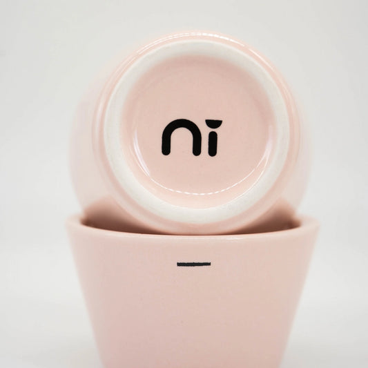 Two pink ceramic espresso cups stacked on a white background, featuring 'Ni' - Ni wares logo on the underside of the cup - Basic Barista Coffee gear online Espresso Coffee Gear