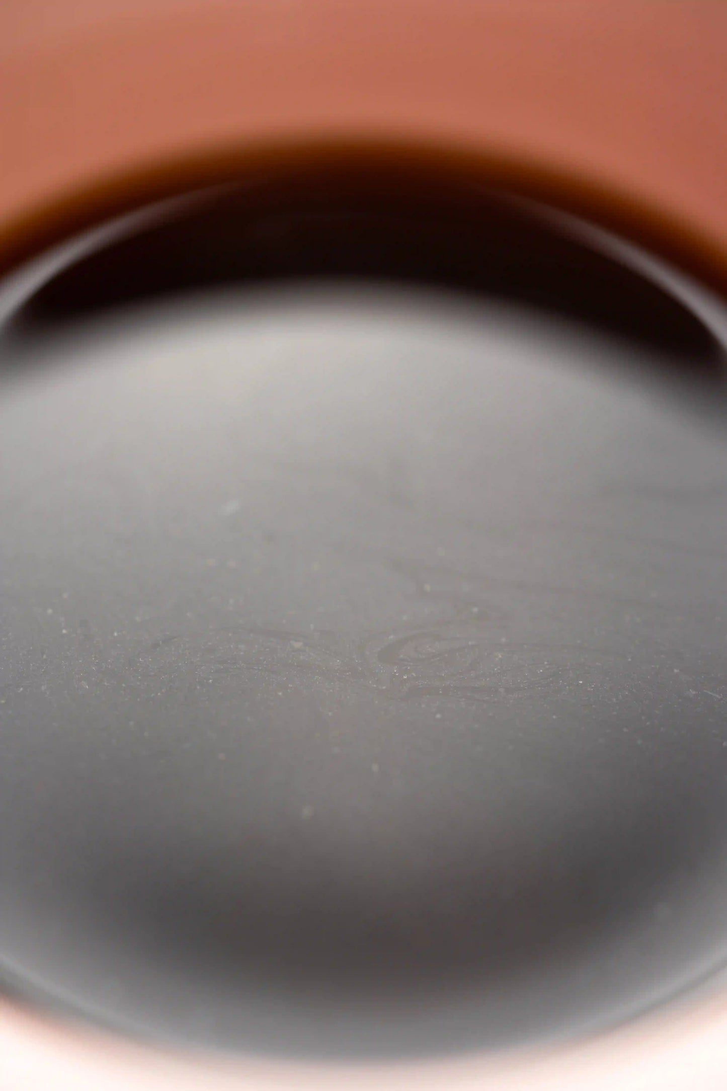 close up of Origami Sensory Cup Pink specialty coffee cup with coffee oils floating on the surface of the coffee. Basic Barista coffee science 