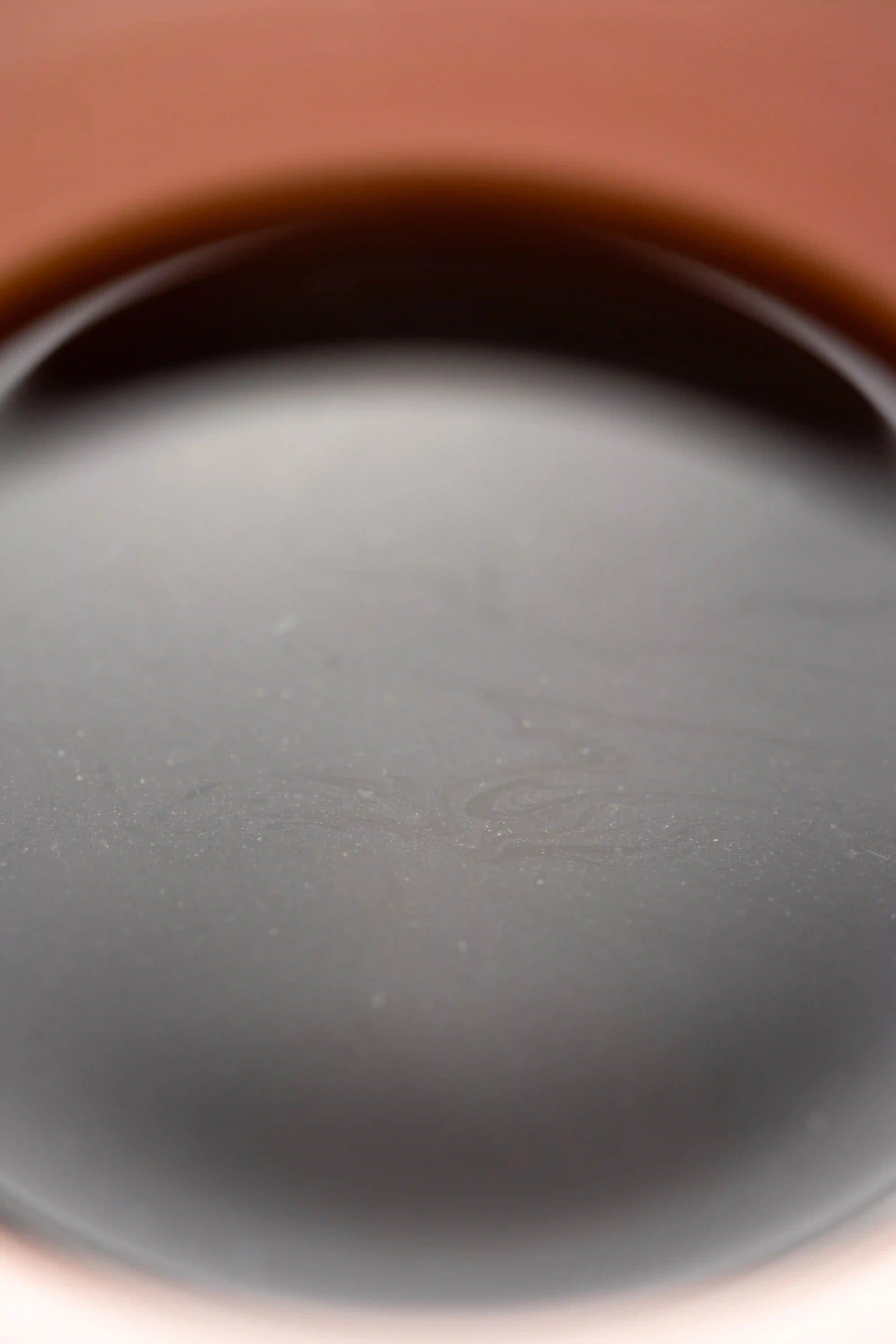 close up of Origami Sensory Cup Pink specialty coffee cup with coffee oils floating on the surface of the coffee. Basic Barista coffee science 