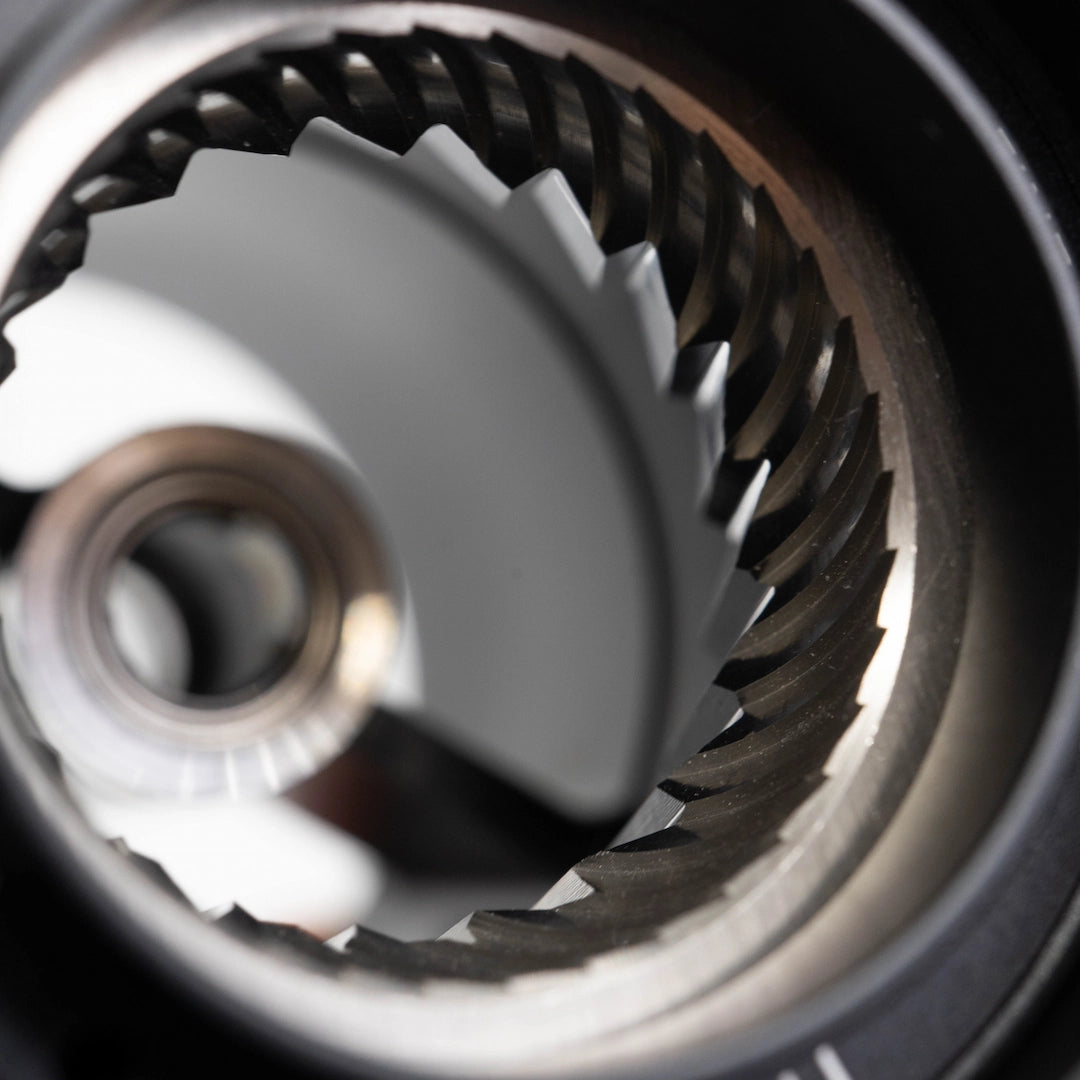 Close-up of a coffee grinder burr set mechanism with a blurred background - Basic Barista Coffee Gear Online