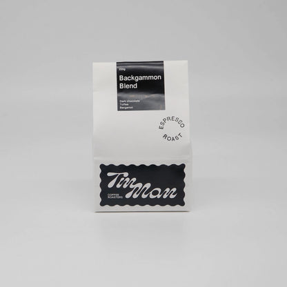 Coffee package labeled 'Backgammon Blend' by Tin Man Coffee Roasters on a gray background Backgammon Blend Roasted Coffee Beans Basic Barista