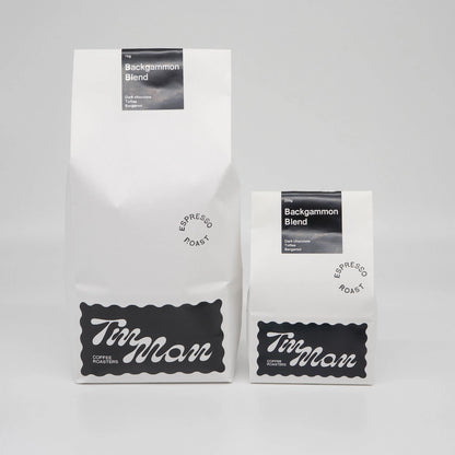 Two coffee bags labeled 'Tim Man Coffee Roasters' on a gray background Backgammon Blend Roasted Coffee Beans Basic Barista