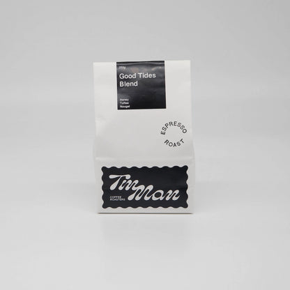 Coffee package labeled 'Good Tides Blend' by 'Tin Man' on a grey background Roasted Coffee Beans Basic Barista